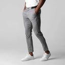 Person wearing grey 4-Way Stretch Chinos from GolfThing and white sneakers on a plain background