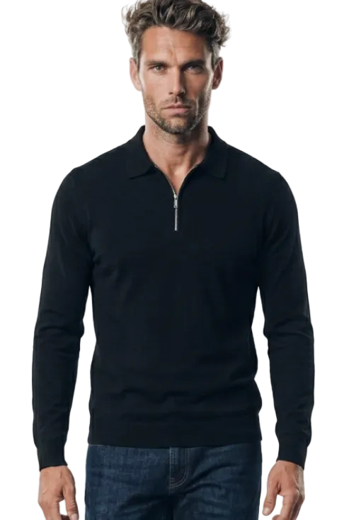 A man modeling a black long-sleeve quarter-zip golf jumper, dark blue jeans, and white sneakers against a plain white studio background.