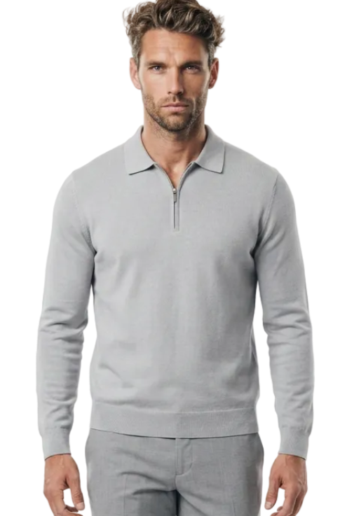 A man modeling a light gray long-sleeve quarter zip golf jumper  and matching gray trousers against a plain white studio background.