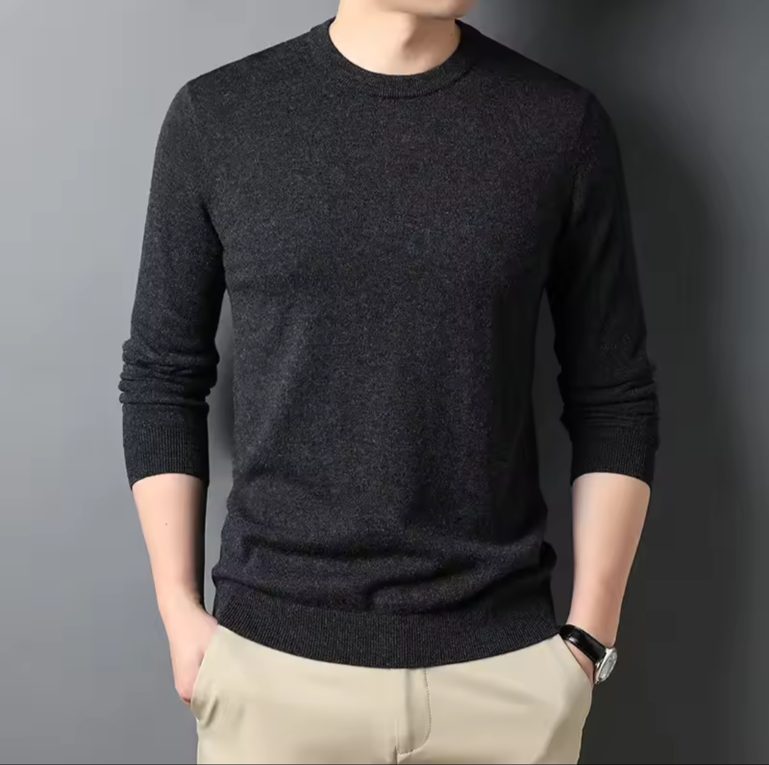 Golf sweater in dark charcoal grey knit with a classic round neckline, long sleeves, and ribbed cuffs and hem